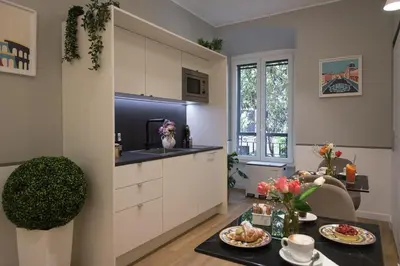 a kitchen with white cabinets and a table with food at Colosseum suites by Glen in Rome