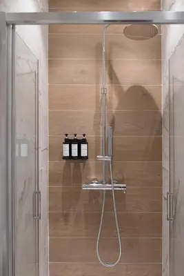 a shower with a glass door in a bathroom at Colosseum suites by Glen in Rome