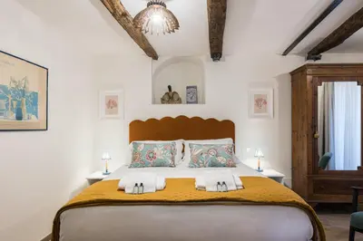 a bedroom with a large bed and a chandelier at Rome As You Feel - Trastevere Nest with Secret Patio in Rome