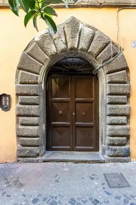 a large wooden door in a stone archway at Rome As You Feel - Trastevere Nest with Secret Patio in Rome