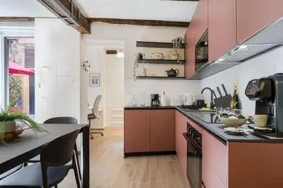 a kitchen with pink cabinets and a counter top at Rome As You Feel - Trastevere Nest with Secret Patio in Rome