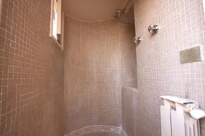 a tiled bathroom with a shower and a toilet at Navona Large 1BR Holiday House in Rome