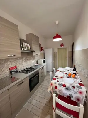 a kitchen with a dining table and a kitchen with a refrigerator at Casa Dea Piramide in Rome