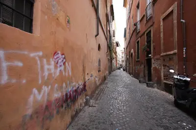 an alley with graffiti on the side of a building at Navona Opera Holiday House in Rome
