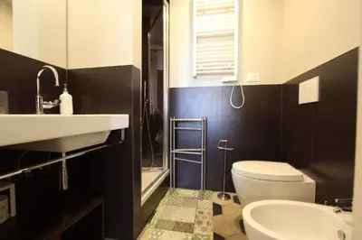 a bathroom with a white toilet and a sink at Navona Opera Holiday House in Rome