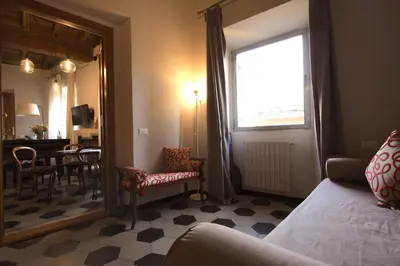 a living room with a bed and a mirror and a table at Navona Opera Holiday House in Rome
