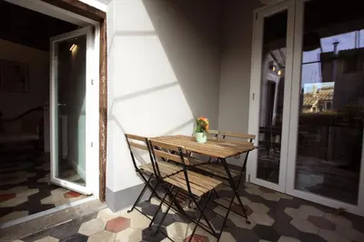 a wooden table with a vase on it on a porch at Navona Terrace 2BR Holiday House in Rome