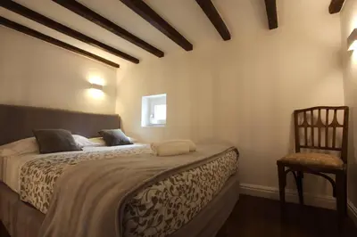 a bedroom with a large bed and a chair at Navona Terrace 2BR Holiday House in Rome