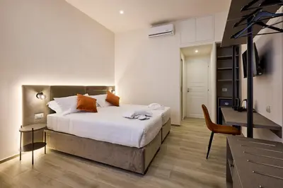 a bedroom with a bed and a desk and a chair at Urban Guesthouse Monti in Rome