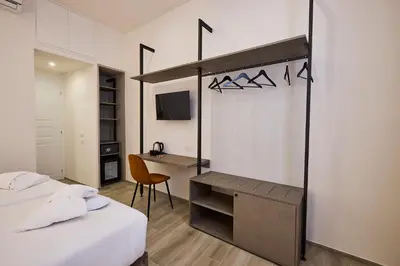 a hotel room with two beds and a desk and a desk at Urban Guesthouse Monti in Rome