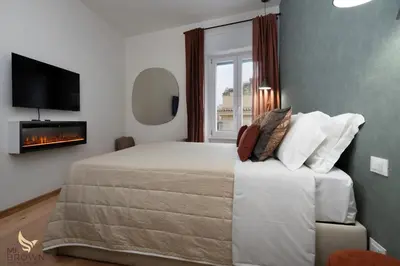 a bedroom with a large bed and a fireplace at MrBrown - Dimora Lucrezia al Vaticano in Rome