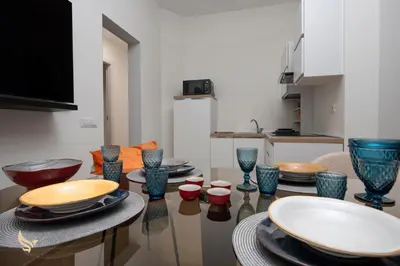 a dining room with blue glass bowls and plates on a table at MrBrown - Dimora Lucrezia al Vaticano in Rome