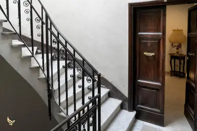 a hallway with a staircase with a wooden door at MrBrown - Dimora Lucrezia al Vaticano in Rome