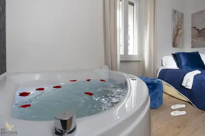 a bath tub with red roses in a room at MrBrown - Dimora Lucrezia al Vaticano in Rome