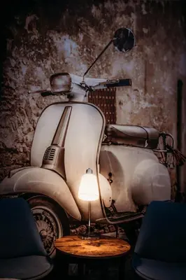 a white scooter parked in a room with a lamp at NL Trastevere in Rome