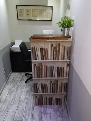 a book shelf filled with books next to a desk at NL Trastevere in Rome