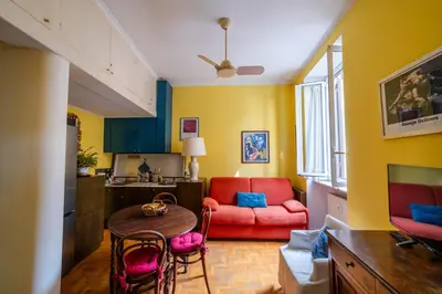 a living room with a red couch and a table at Oasi Tiberina in Rome