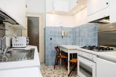 a living room with a blue couch and a desk at La casa dell'artista in Rome