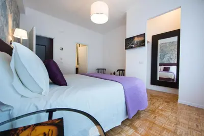 a bedroom with a large white bed and a glass table at B&B Roma 474 in Rome