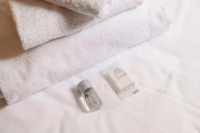 a bottle of soap and towels on a bed at Studio House da Pasolini a Mastroianni in Rome