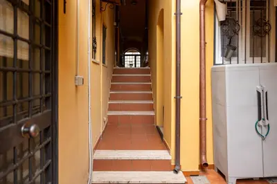 a hallway with stairs in a building with yellow walls at Studio House da Pasolini a Mastroianni in Rome