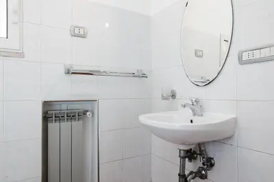 a white bathroom with a sink and a mirror at Studio House da Pasolini a Mastroianni in Rome