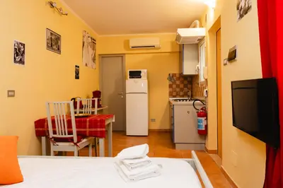 a small kitchen with a refrigerator and a table at Studio House da Pasolini a Mastroianni in Rome