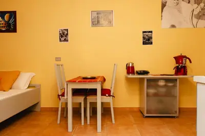 a room with a table and chairs and a couch at Studio House da Pasolini a Mastroianni in Rome