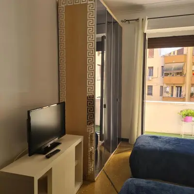 a room with a tv and a bed and a window at Red Moon House - tra Policlinico e Piazza Bologna in Rome
