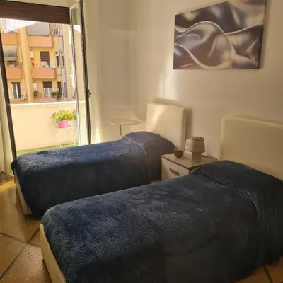 a room with two beds with blue covers on them at Red Moon House - tra Policlinico e Piazza Bologna in Rome