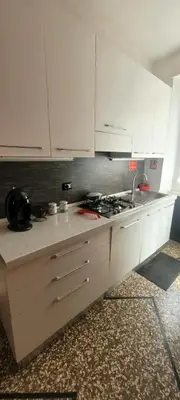 a kitchen with white cabinets and a stove top oven at Red Moon House - tra Policlinico e Piazza Bologna in Rome