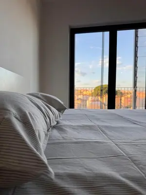 a bedroom with a bed and a large window at Alberto's panoramic flat in Rome