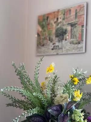 a vase filled with flowers in front of a painting at Alberto's panoramic flat in Rome