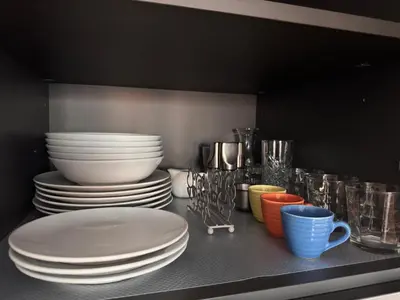 a shelf with plates and bowls and cups on it at Alberto's panoramic flat in Rome