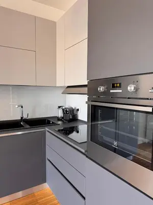 a kitchen with stainless steel appliances and white cabinets at Alberto's panoramic flat in Rome
