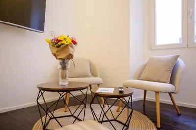 a living room with two chairs and a vase of flowers at Cunabu Sardegna in Rome