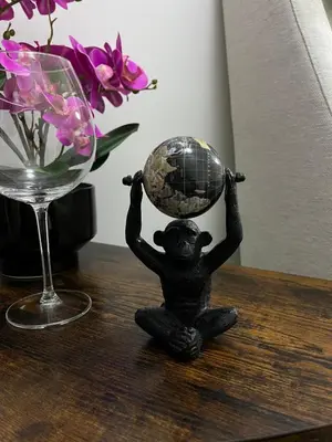 a small statue of a monkey holding a globe on a table at RenMa Caffarella House in Rome