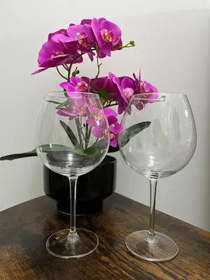 two wine glasses and a vase with purple flowers at RenMa Caffarella House in Rome