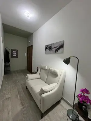 a living room with a white couch and a lamp at RenMa Caffarella House in Rome