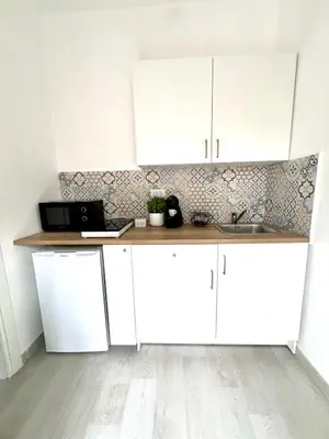 a kitchen with white cabinets and a sink at Augusto's House b&b in Rome