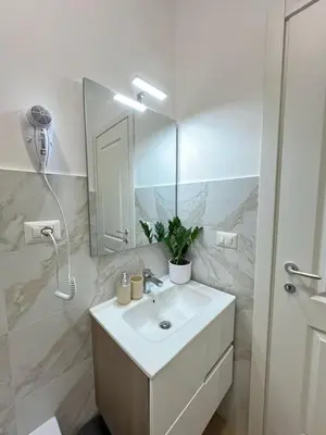 a white bathroom with a sink and a mirror at Augusto's House b&b in Rome