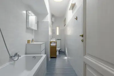 a white bathroom with a tub and a sink at Macro House in Rome