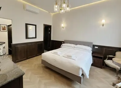 a bedroom with a large bed and a chandelier at Belle Epoque in Rome