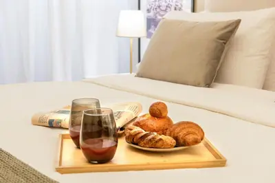 a tray of bread and a glass of wine on a bed at Urban Oasis Metro B Piramide - 2 subway stations from Colosseo in Rome