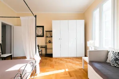 a bedroom with a bed and a white cabinet at Home Domus Giulio Cesare - Vatican Museum in Rome