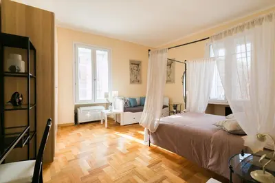 a bedroom with a bed with curtains and a wooden floor at Home Domus Giulio Cesare - Vatican Museum in Rome