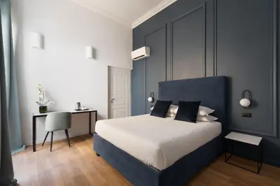 a bedroom with a bed and a desk with a chair at DA ME Suites in Rome