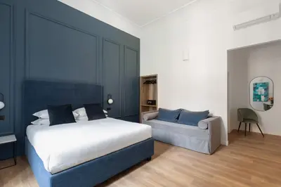 a bedroom with a bed and a couch at DA ME Suites in Rome