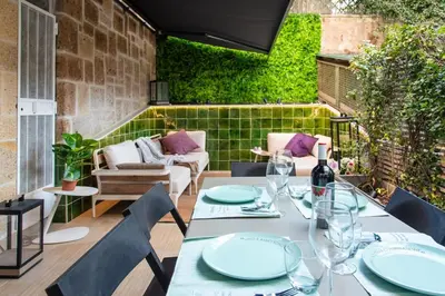 a table with chairs and a bottle of wine on a patio at Fabiolous suites in Rome