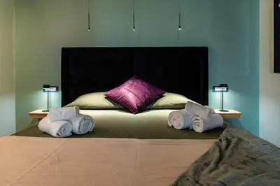 a bed with three towels on it with two lamps at Fabiolous suites in Rome